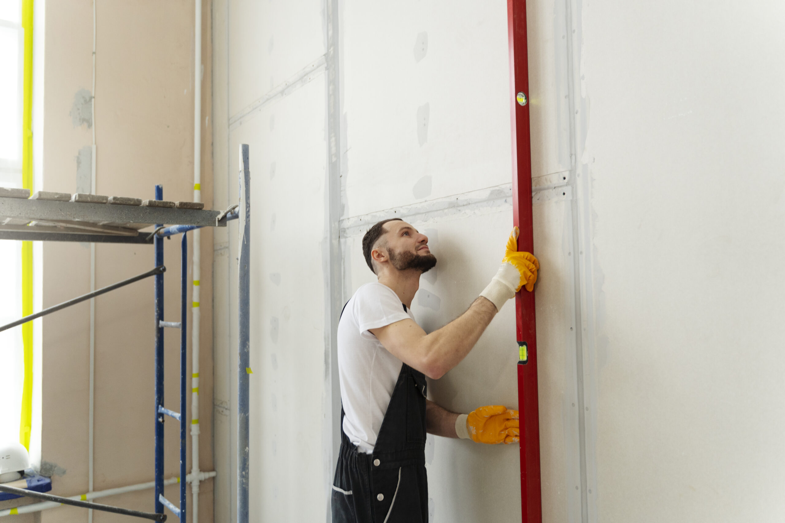 Skilled technician installing drywall panels on an interior wall frame